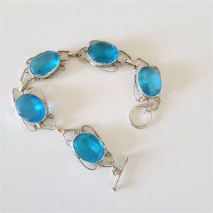 Silver color metal and blue stones bracelet.